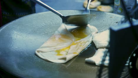 4k cinematic cooking footage of a thai chef preparing a traditionnal thai dessert called roti in a street market in thailand