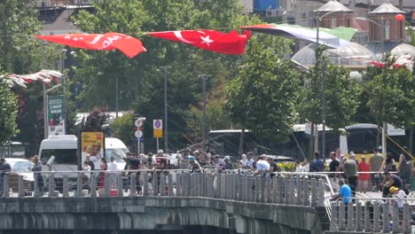 people fishing on a bridge in a city with flags