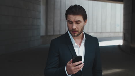 Businessman-using-smartphone-at-street.Entrepreneur-texting-texting-on-cellphone