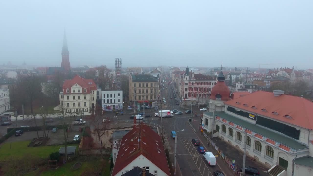 Traffic on a Crossroad in Leipzig, Germany on a misty day. 4K Forward moving Aerial Drone Shot.