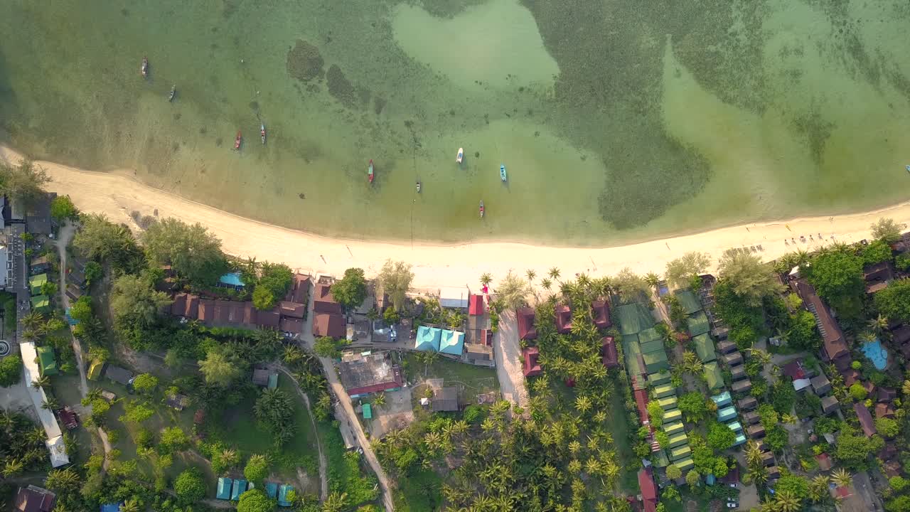 4k съемка с беспилотного летательного аппарата на салатовом пляже на острове кох пханган в таиланде с рыбацкими лодками, чистейшей водой, кораллами и зелеными джунглями