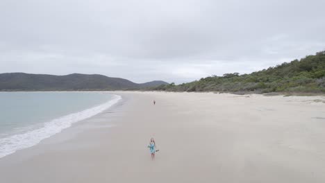 Pareja-Caminando-En-La-Playa-De-Arena-De-La-Isla-Great-Keppel-En-Queensland,-Australia---Toma-Aérea