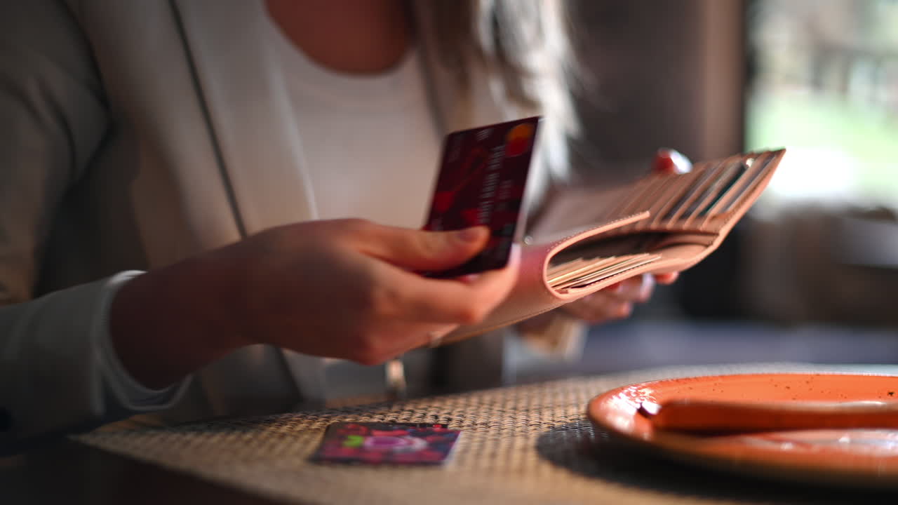 Mulher procurando a carteira e pegando o cartão de crédito para pagar em um restaurante