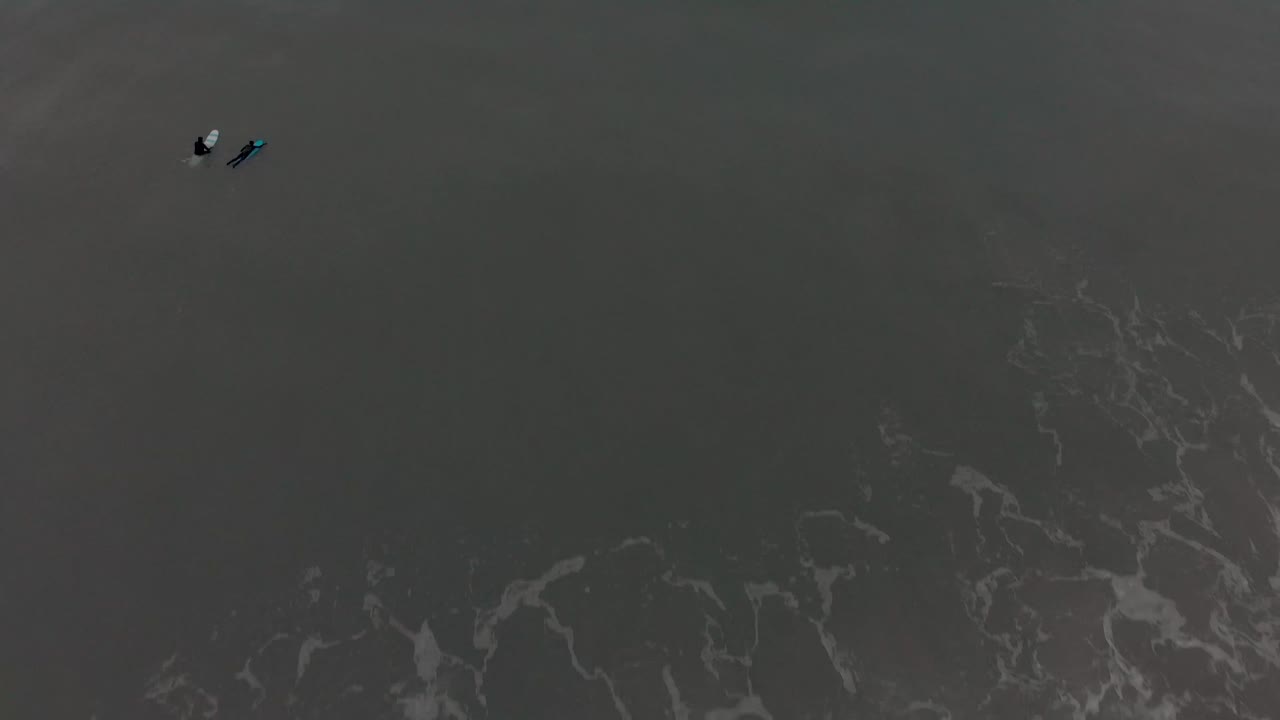 미국 매사추세츠주 헐의 난타스켓 해변에서 파도가 튀는 바다에 떠 있는 서핑보드를 타는 서퍼들