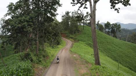 Mann,-Der-Motorrad-Auf-Unbefestigter-Unbefestigter-Straße-In-Grünen-Landschaftsbergen-Von-Thailand-Fährt