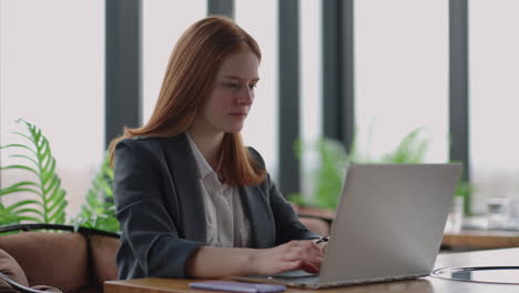 financial specialist of big modern company is working in office young pretty lady is sending email by laptop