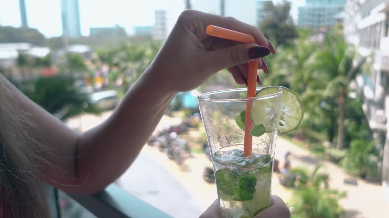 여자 는 발코니 에 서서 민트 와 함께 달 ⁇  한  ⁇ 테일 을  ⁇ 는다