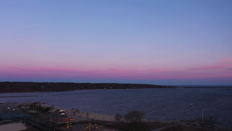 an aerial view over an empty park looking at the bay during a beautiful sunrise