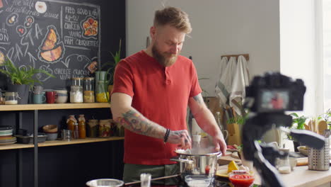 food blogger cooking food and talking on camera in kitchen