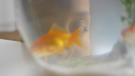 girl-looking-at-goldfish-in-bowl-watching-fish-swimming-in-aquarium-child-smiling-happy-enjoying-aquatic-pet-4k