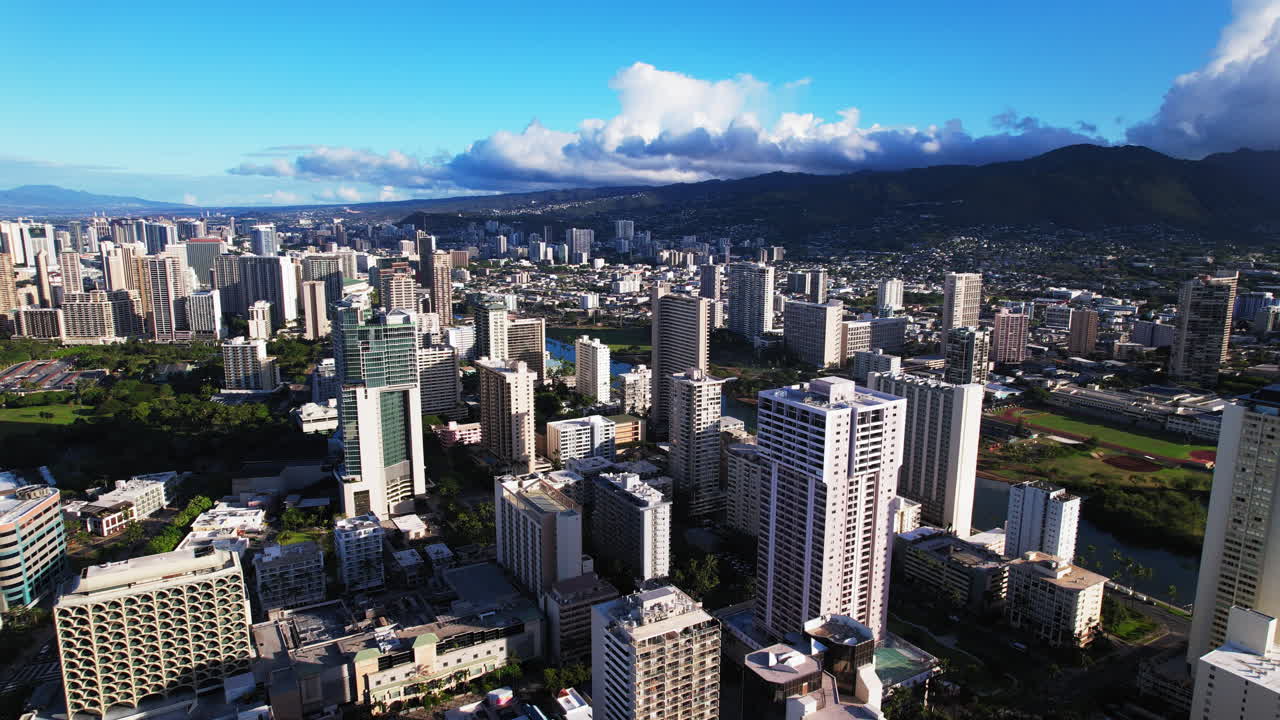 Vista a volo d'uccello del centro di Honolulu, Hawaii - vista aerea orbitante di edifici e montagne