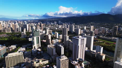 Bird's-eye-view-of-downtown-Honolulu-Hawaii---aerial-orbiting-view-of-buildings-and-mountains