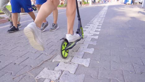 male feet riding scooter in the city.