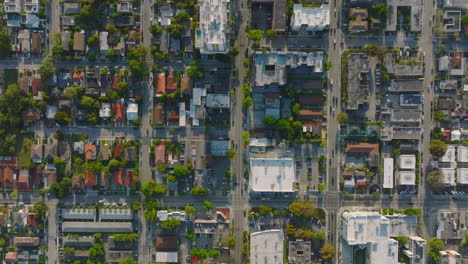 Top-down-panning-footage-of-family-houses-and-apartment-buildings-in-residential-urban-borough-at-golden-hour.-Miami,-USA