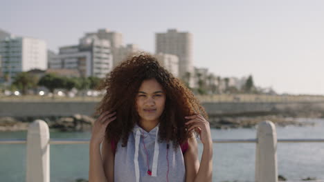 portrait of beautiful woman with afro hair looking serious pensive thoughtful on beachfront