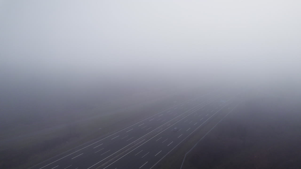 밀집한 구름을 통해 공중  ⁇ 으로 날아다니며 구름이 많은 날에 자동차를 운전하는 독일 고속도로를 드러 ⁇ 니다.