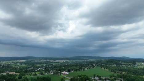 An-aerial-time-lapse-view-of-storm-clouds-passing-over-the-lush-green-farmland-in-the-summer-season