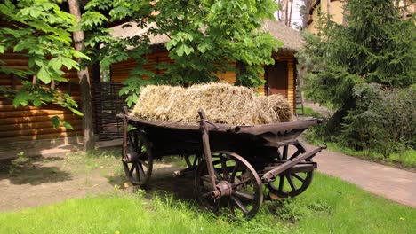 antique wooden wagon with hay in a garden setting