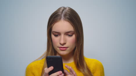 Portrait-of-attractive-pretty-woman-using-smartphone-on-grey-background.