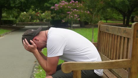 contemplative moment on a bench, deep in thought with head in hands