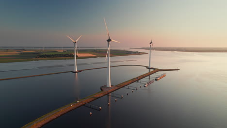 aerial view of wind turbines on calm water at sunset