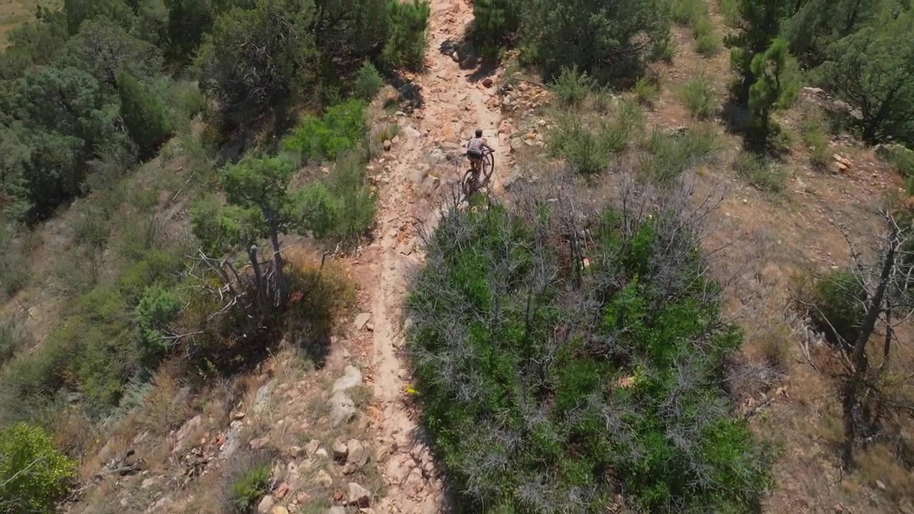 Mountain Biking Bike sport fitness Red Rocks Morrison Golden Colorado aerial drone birdseye pan up Dakota Ridge Trail Denver Green Mountain foothills front range adult male biker day hot sunny