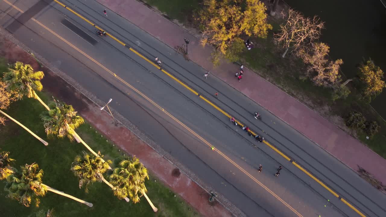 일몰 시 부에노스아이레스 시의 팔레르모 공원에서 운동하는 사람들의 공중 하향식 촬영 - 일몰 동안 공원에서 길을 달리고 걷기