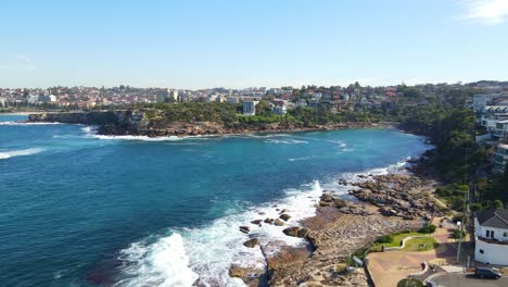 waves crashing on rocky coast with gordons bay beach at daytime - coogee city from clovelly, nsw, australia