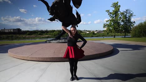 female dancer dancing outside next to the sculpture