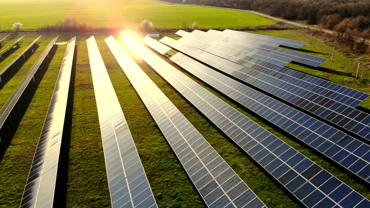 Luftfoto af industrielle solcelleanlæg, der producerer vedvarende grøn energi.