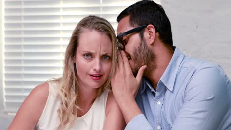 casual businessman whispering a secret to colleague