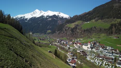 uphill camera drive above neustift in stubai valley in austria, with snow covered mountains in the background