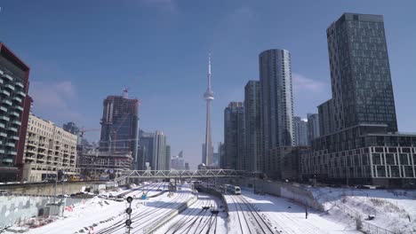 centro de toronto, torre cn, edificios de condominios, tren de transporte ferroviario durante el invierno