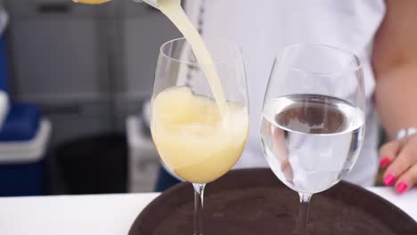 slowmo - beautiful blond hair woman pouring glass of fermented young moravian wine federweisser - close up