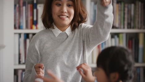 happy asian family dancing at home mother enjoying funny dance with daughter having fun exciting weekend together 4k footage