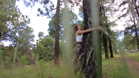 young attractive latin girl hugging a tree at a forest woods on a summer day near puebla mexico