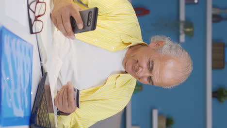 Video-Vertical-De-Un-Anciano-Trabajador-De-Oficina-En-Casa-Comprando-Por-Teléfono.