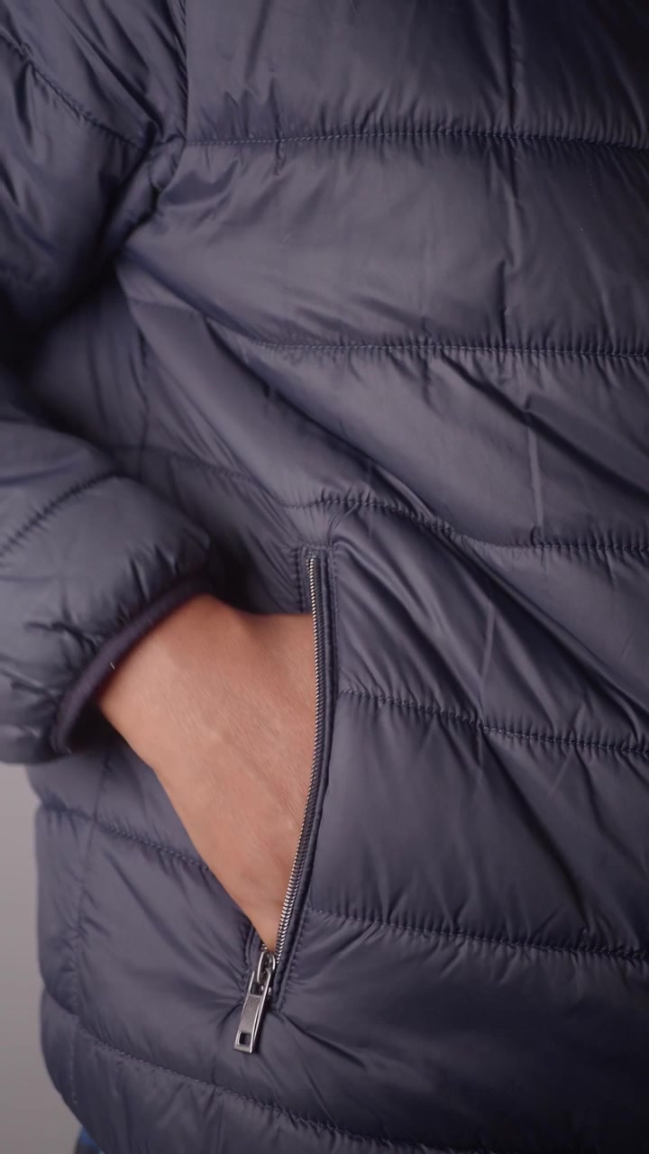 Person Putting Hand Into Pocket of Puffer Jacket