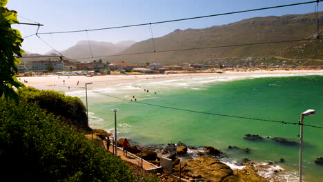 Strandtag-Am-Weißen-Sandstrand-Von-Fish-Hoek-Mit-Schwimmenden-Menschen