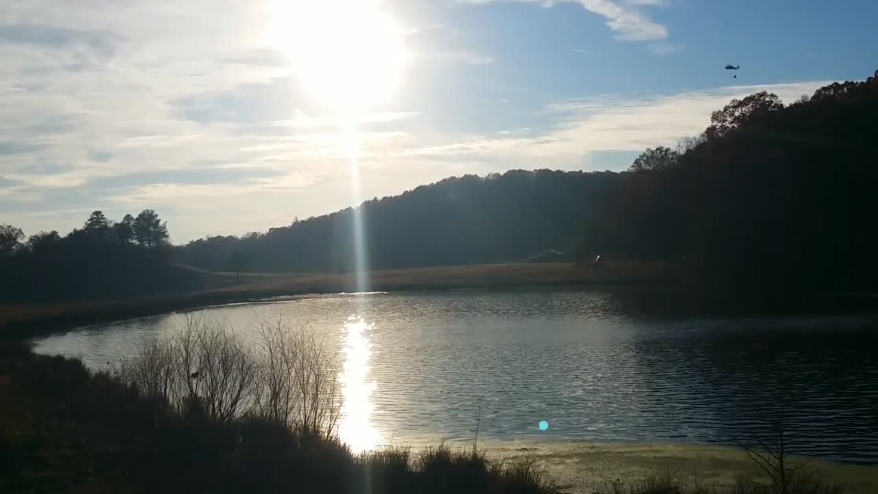 육군 방위군 블랙 호크 헬리콥터는 산에서 화재를 진압하기 위해 밤비 양동이로 물을 얻습니다.