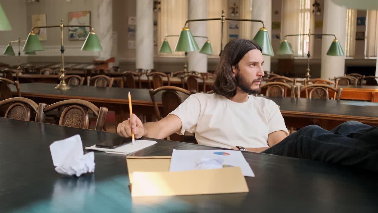 joven estudiante pensando en un proyecto de estudio en la biblioteca