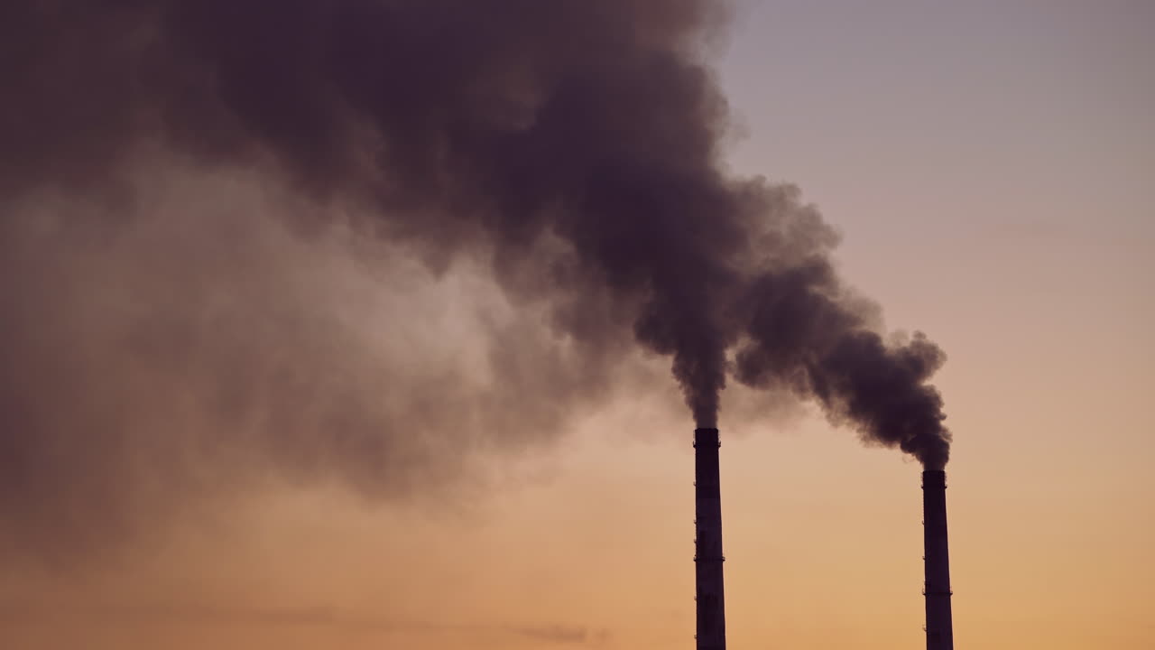 Industrial zone in the city. Air pollution by smoke coming out of two factory chimneys