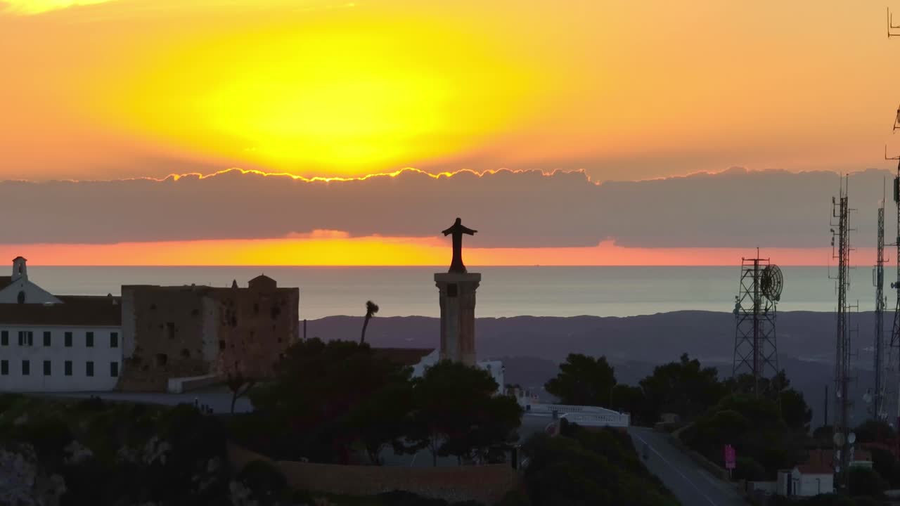 스페인 메노르카에서 가장 큰 산봉우리 동상 뒤의 일출