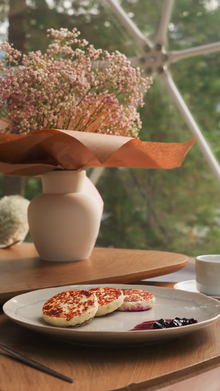 낮은 테이블에 제공 된 가을 꽃을 가진 꽃병. 쾌적한 의자와 인 커피 테이블은 호수의 멋진 전망에 대한 아침 식사를 즐기기 위해 완벽한 장소를 만니다.