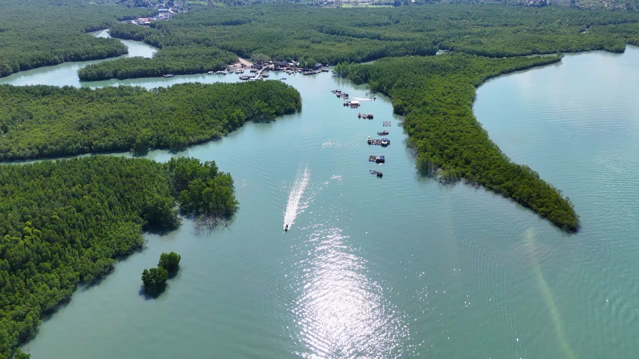 드론 영상은 태국 나가의 평화로운 맹그로브와 휘어지는 강을 포착합니다. 배와 물 위의 빛 반사와 함께.