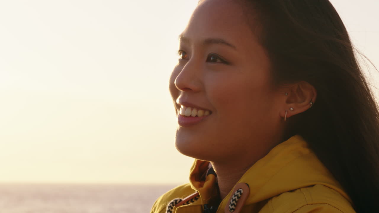 portrait of beautiful asian woman enjoying seaside at sunset exploring spirituality looking up praying contemplating journey relaxing on beach