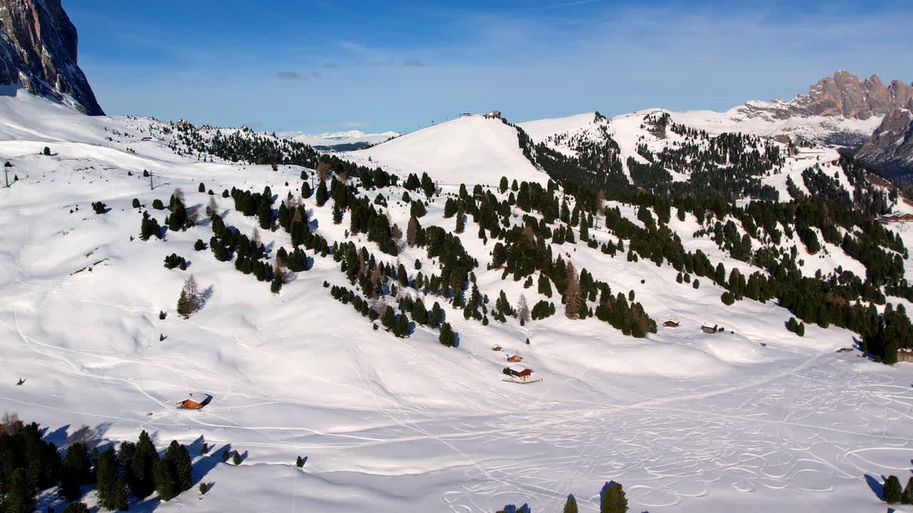 눈으로 인 초원과 돌로마이트 산맥에 어져 있는 나무들의 아름다운 공중 영상으로 평온한 겨울 풍경을 보여줍니다.