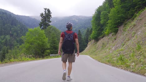 Man-walking-on-empty-road.