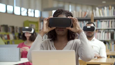 focused african american woman wearing virtual reality glasses