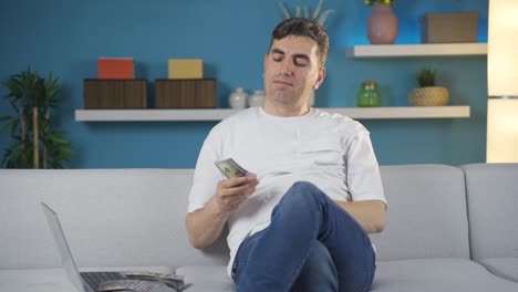 el hombre con mucho dinero se está riendo en casa.